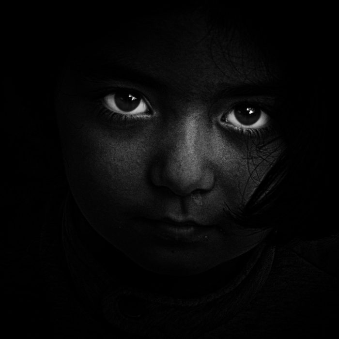 bw photo of child in darkness