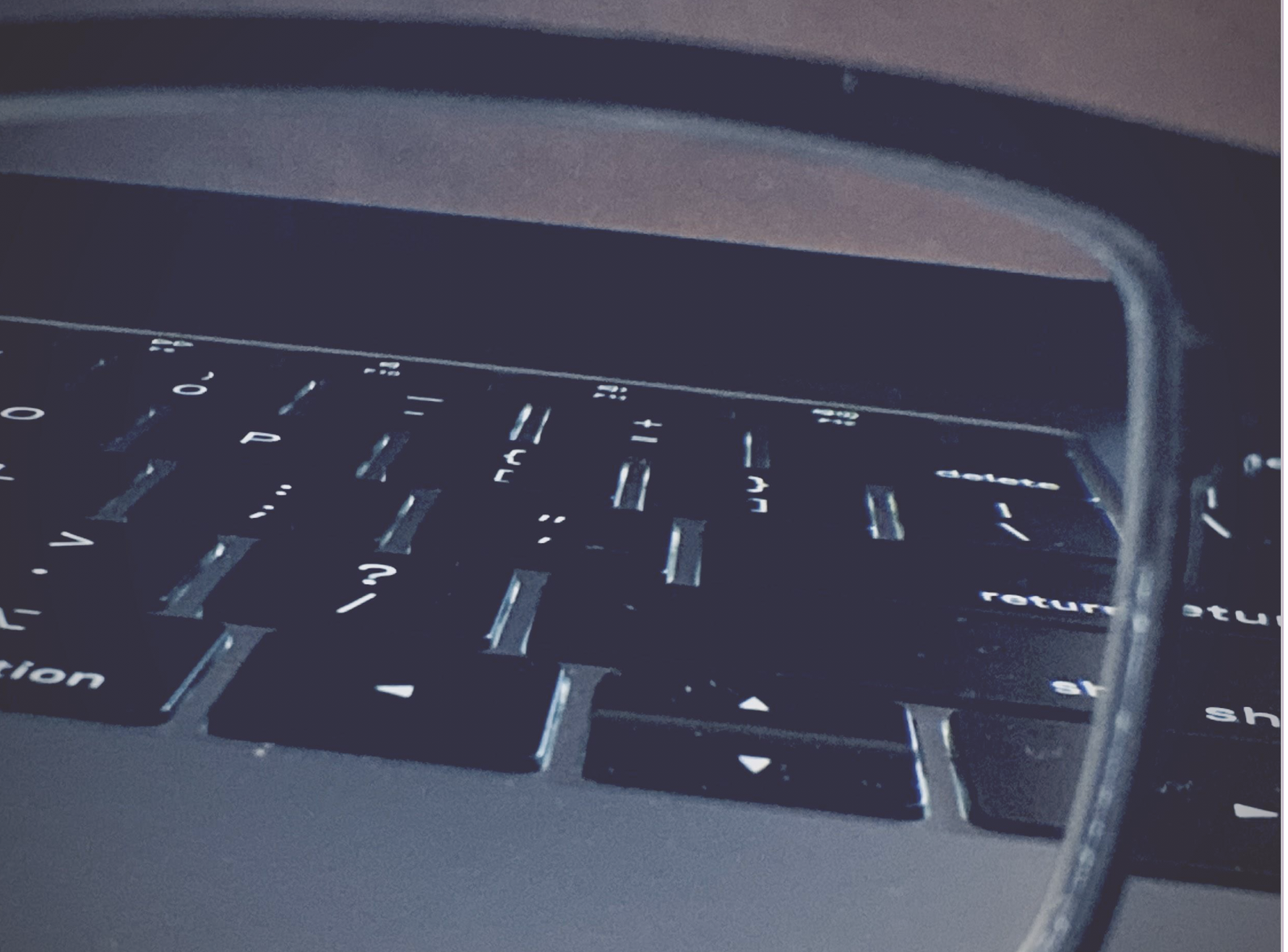 view of laptop keyboard through the lens of a pair of eye glasses