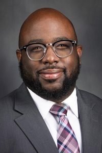 portrait: black man with beard, mustache and glasses, bald