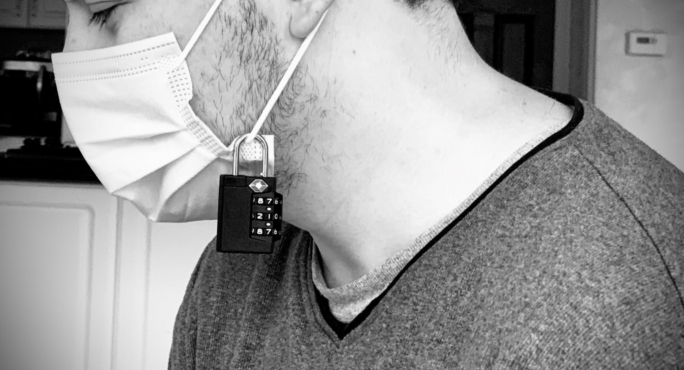 side view of man wearing medical mask with a combination lock on it