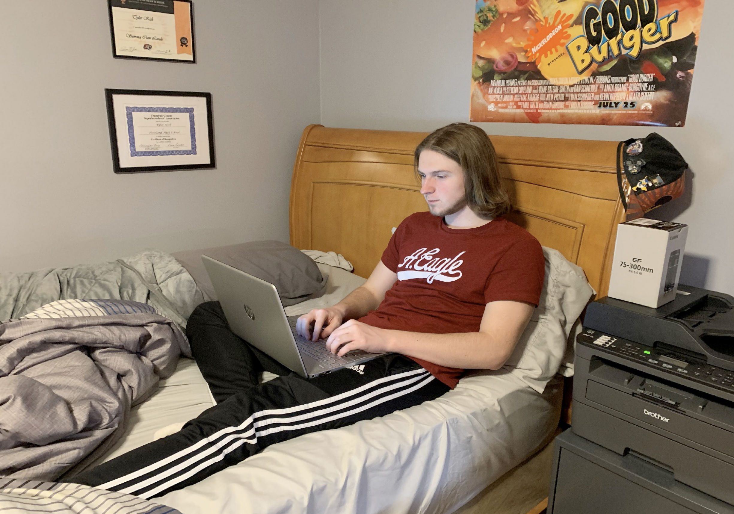 man lounging on bed with laptop